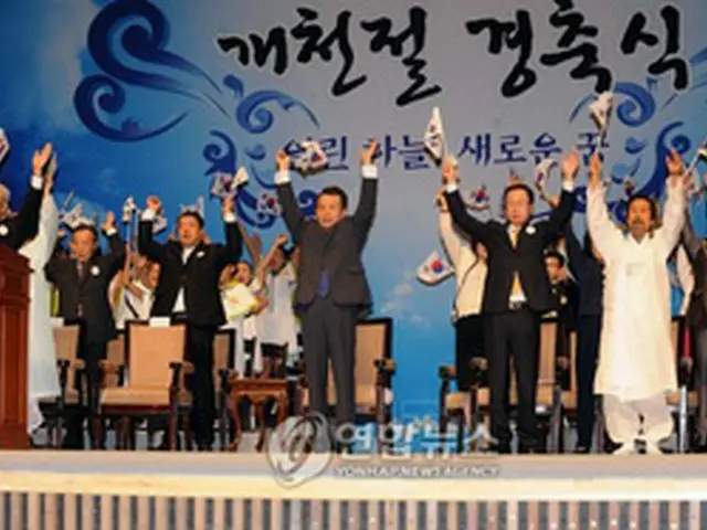 慶祝式で万歳三唱する韓首相ら＝3日、ソウル（聯合）