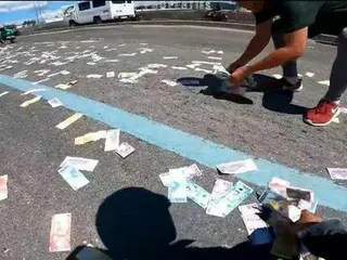 道路上に散らばった400万ペソの紙幣…道路は修羅場