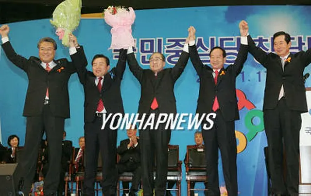 忠清道を地盤とする国民中心党が旗揚げされ、沈大平知事（中央）、辛国煥議員（右から２番目）ら、党執行部が手を上げあいさつしている＝１７日、ソウル（聯合）