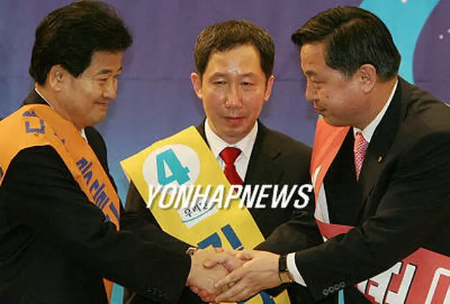 全党大会の予備選挙で得票トップだった鄭東泳常任顧問（写真左から）、２位の金槿泰常任顧問、３位の金斗官政務特補が握手を交わしている＝２日、ソウル（聯合）