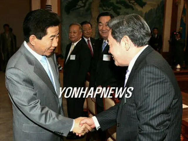 会議前に李健熙サムスングループ会長と握手する盧武鉉大統領（左）＝２４日、ソウル（聯合）