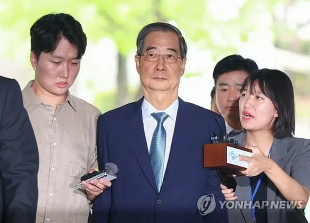 令状審査に出席するため、ソウル中央地裁に入る韓悳洙前首相（中央）＝２７日、ソウル（聯合ニュース）