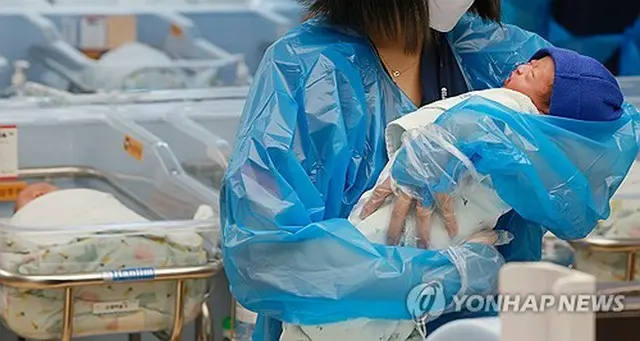 京畿道高陽市内の病院で新生児を抱いている看護師＝（聯合ニュース）