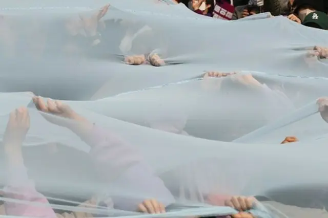 ２０２３年の国際女性デーを前に韓国の女性団体がガラスの天井を破るという意味のパフォーマンスを披露している＝（聯合ニュース）