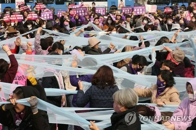 女性差別の撤廃を訴えてパフォーマンスを行う市民団体の関係者ら＝（聯合ニュース）