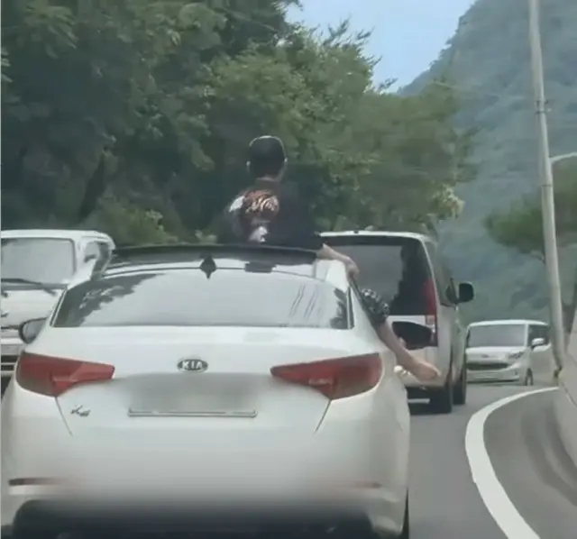 「まるでサーカス？」…サンルーフから上半身、窓から足を出した男性＝韓国