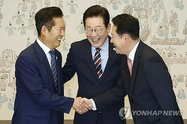 握手を交わす「共に民主党」の鄭清来代表（左）と「国民の力」の張東赫代表。中央は李在明大統領＝８日、ソウル（聯合ニュース）