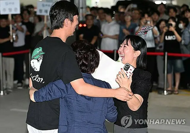 家族との再会を喜ぶ帰国者＝１２日、仁川（聯合ニュース）