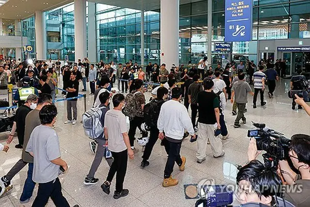仁川国際空港に到着した韓国人労働者ら＝１２日、仁川（聯合ニュース）