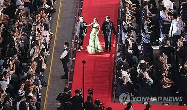 釜山国際映画祭の開会式でレッドカーペットを歩く俳優ら＝１７日、釜山（聯合ニュース）
