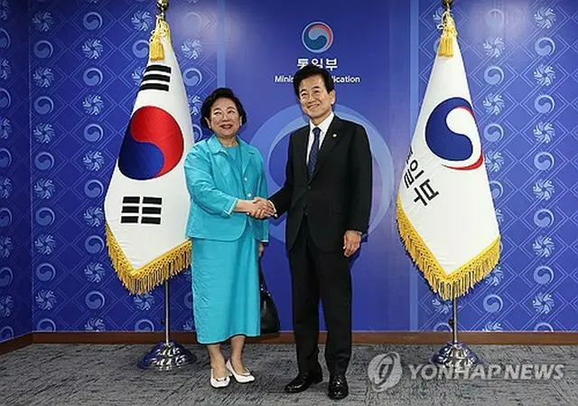 握手を交わす玄貞恩氏（左）と鄭東泳氏＝２２日、ソウル（聯合ニュース）
