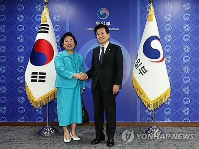 握手を交わす玄貞恩氏（左）と鄭東泳氏＝２２日、ソウル（聯合ニュース）