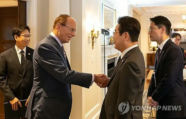 フィンク氏（手前左）と握手を交わす李大統領＝２２日、ニューヨーク（聯合ニュース）