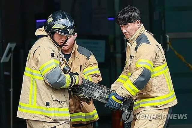 国家情報資源管理院で全焼したバッテリーを持ち出す消防隊員＝２７日、大田（聯合ニュース）