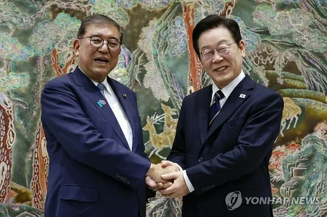 握手する李大統領（右）と石破首相＝３０日、釜山（聯合ニュース）