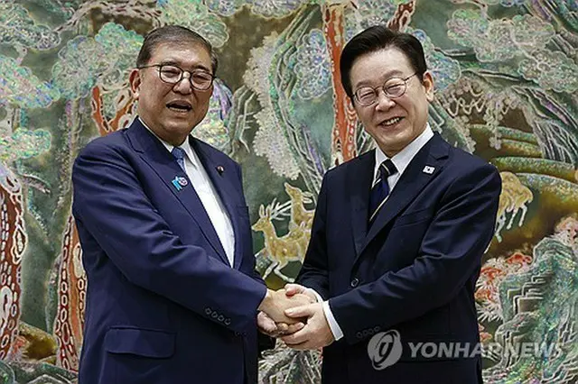 握手する李大統領（右）と石破首相＝３０日、釜山（聯合ニュース）