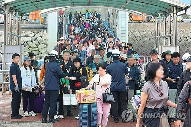 仁川港沿岸旅客ターミナルで船に乗り込む帰省客ら＝２日、仁川（聯合ニュース）