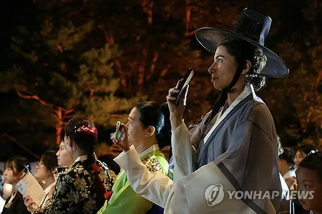 ８日に景福宮で開かれた「宮中文化祝典」の行事を楽しむ外国人観光客＝（聯合ニュース）
