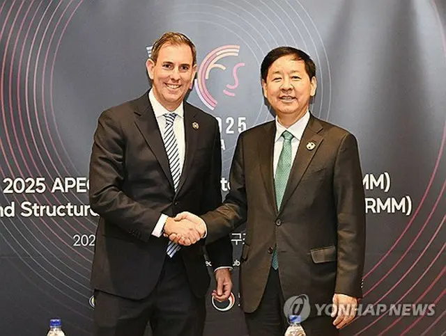 オーストラリアのチャルマーズ財務相（左）と握手を交わす具潤哲氏（企画財政部提供）＝（聯合ニュース）≪転載・転用禁止≫