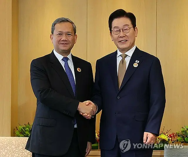 握手を交わす韓国の李大統領（右）とカンボジアのフン・マネット首相＝２７日、クアラルンプール（聯合ニュース）