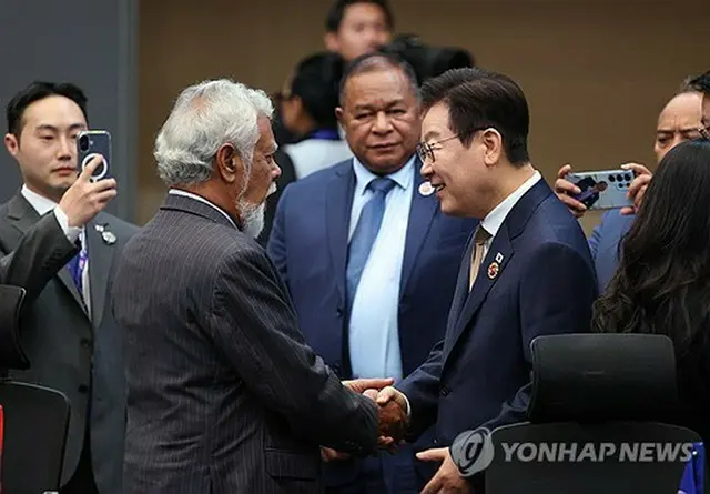 ＡＳＥＡＮへの加盟が決まった東ティモールのシャナナ・グスマン首相（左）と握手する李大統領＝２７日、クアラルンプール（聯合ニュース）