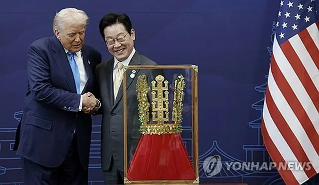 トランプ氏に贈られた金冠のレプリカを前に握手を交わす韓米首脳（大統領室通信写真記者団）＝２９日、慶州（聯合ニュース）