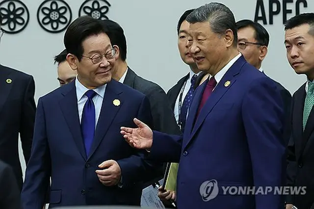 韓国南東部・慶州で開幕したアジア太平洋経済協力会議（ＡＰＥＣ）首脳会議の会場で談笑する李大統領（左）と習国家主席＝３１日、慶州（聯合ニュース）