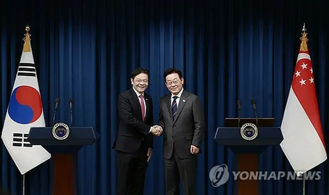 共同記者会見後、握手を交わす韓国の李大統領（右）とシンガポールのウォン首相＝２日、ソウル（聯合ニュース）