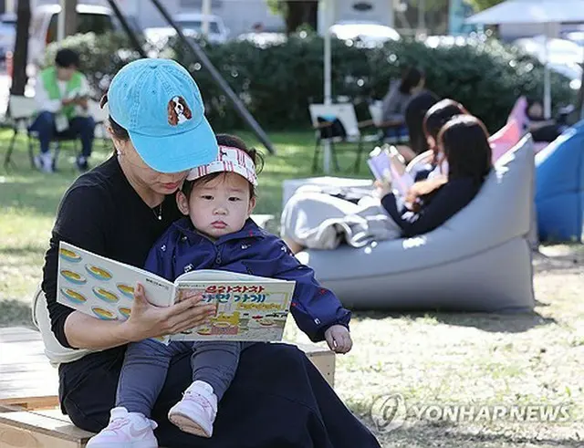 ソウル市内の公園に設置された野外図書館で本を読む市民＝（聯合ニュース）