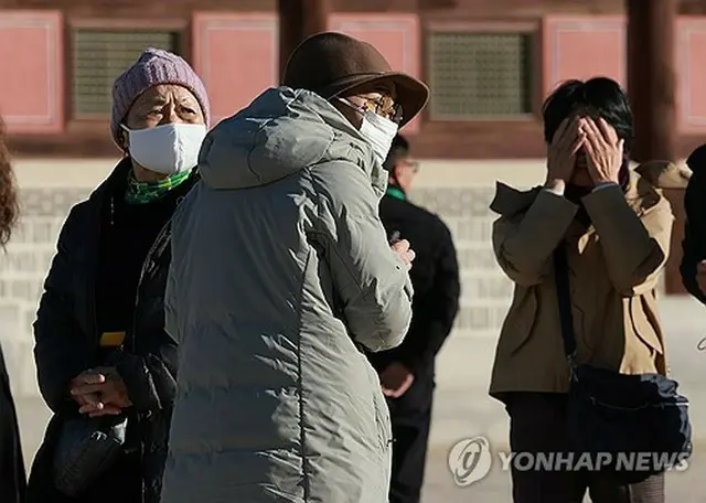 ソウルの旧王宮、景福宮を訪れた外国人観光客が防寒具に身を包んでいる＝１１日、ソウル（聯合ニュース）