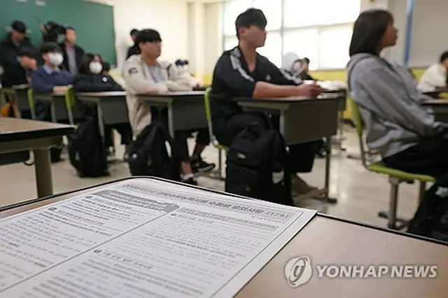 大学修学能力試験を翌日に控え、ソウル市内の高校で受験票の配布を待つ受験生たち＝１２日、ソウル（聯合ニュース）