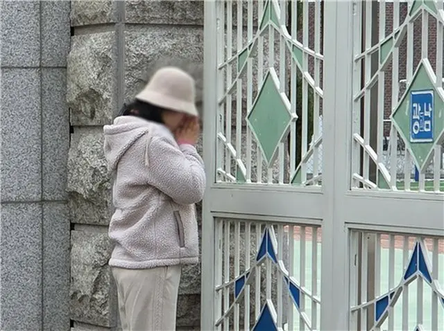 試験会場の前で子どもの合格を祈る保護者＝１３日、ソウル（聯合ニュース）