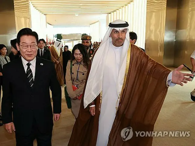 アブダビに到着後、空港で案内を受ける李大統領＝１７日、アブダビ（聯合ニュース）