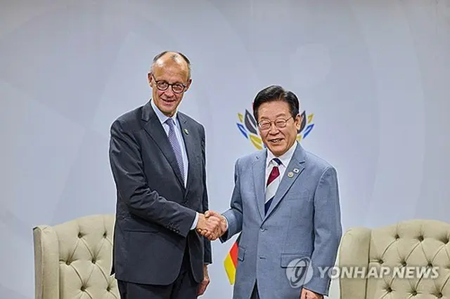 握手を交わす李大統領（右）とメルツ首相＝２２日、ヨハネスブルク（聯合ニュース）