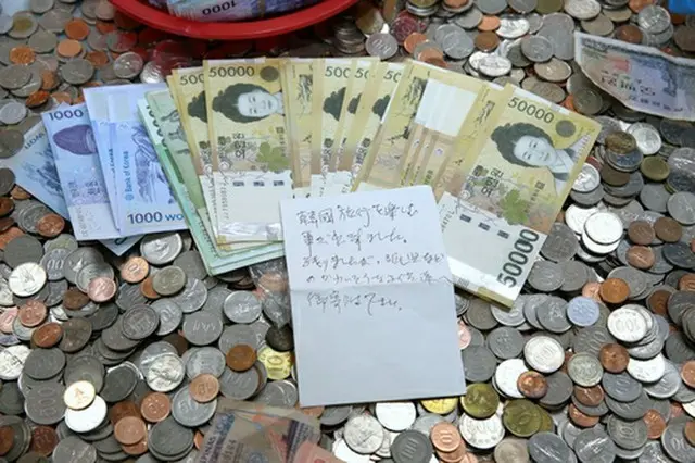 募金箱に入っていた紙幣と手紙（大韓赤十字社釜山支社提供）＝（聯合ニュース）≪転載・転用禁止≫