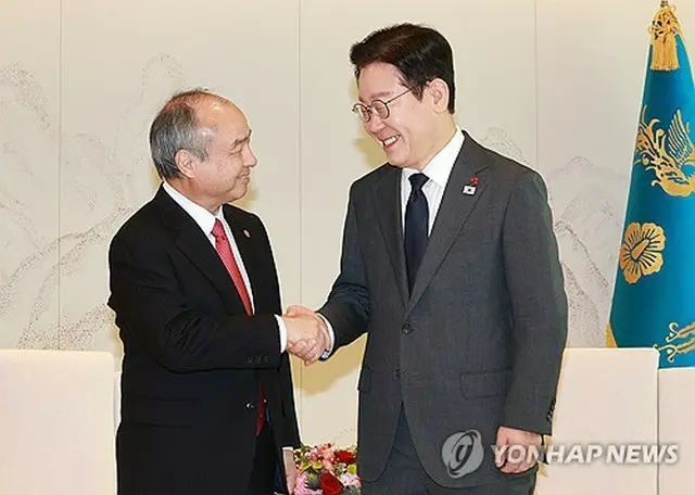 握手を交わす孫正義氏（左）と李大統領（大統領室通信写真記者団）＝５日、ソウル（聯合ニュース）