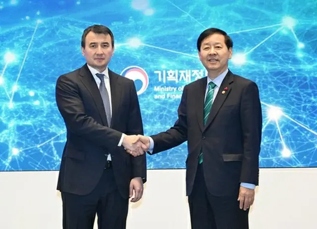 握手を交わすホジャエフ氏（左）と具潤哲氏（企画財政部提供）＝（聯合ニュース）≪転載・転用禁止≫