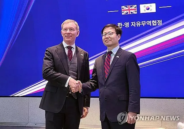 ＦＴＡ改定交渉の妥結を発表する呂翰九・通商交渉本部長（右）とブライアント閣外相＝１５日、ロンドン（聯合ニュース）