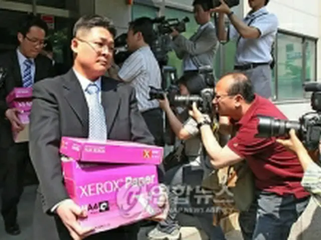 ソウル地方国税庁を家宅捜索し、押収品を運び出す捜査官ら＝６日、ソウル（聯合ニュース）