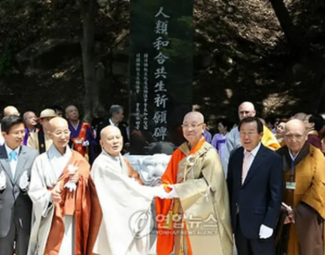 「人類和合共生祈願碑」除幕式で握手を交わす韓国・曹渓宗総務院長の智冠法師（左から3人目）と宮林会長（右から3人目）＝13日、驪州（聯合ニュース）