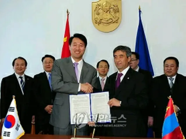 ＭＯＵ締結後、握手する呉市長とムンフバヤル市長＝２６日、ウランバートル（聯合ニュース）