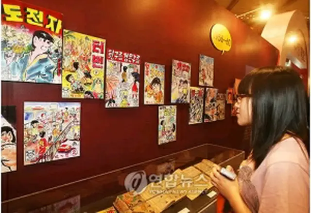 展示された昔の漫画を眺める観客＝22日、ソウル（聯合ニュース）