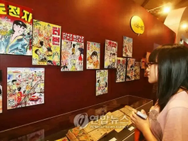 展示された昔の漫画を眺める観客＝22日、ソウル（聯合ニュース）