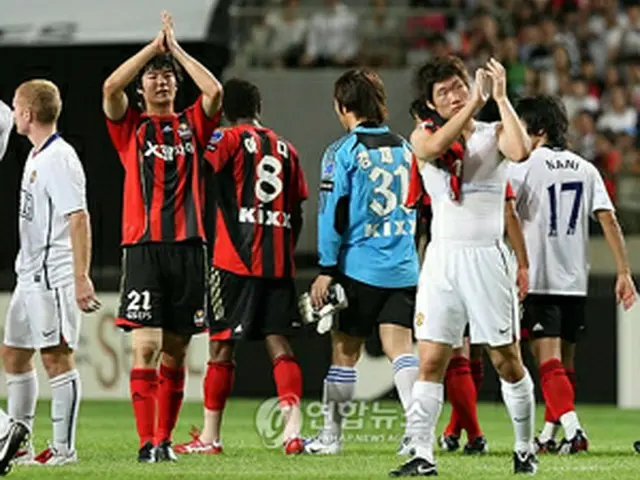 試合を終え、ファンにあいさつするパク・チソン(右)とキ・ソンヨン=24日、ソウル(聯合)