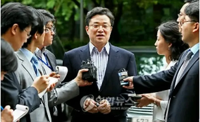 自宅前で報道陣に囲まれる金ジュン圭氏＝28日、ソウル（聯合ニュース）