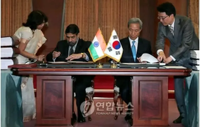 署名を行う金宗フン通商交渉本部長とシャルマ商工相＝７日、ソウル（聯合ニュース）