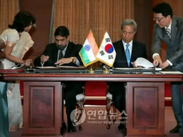 署名を行う金宗フン通商交渉本部長とシャルマ商工相=7日、ソウル(聯合ニュース)