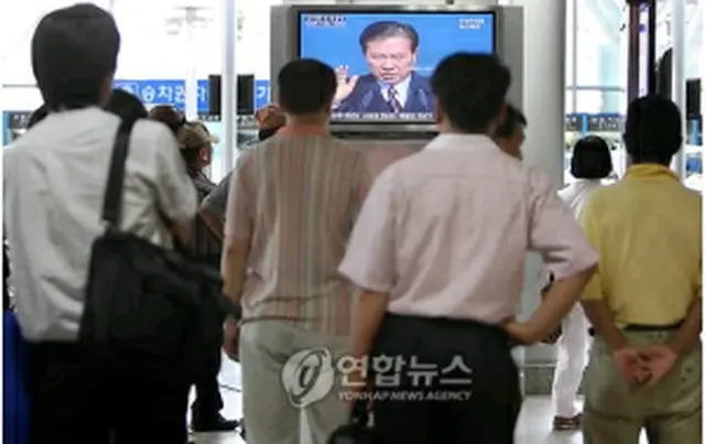 ソウル駅で金元大統領逝去のニュースに釘付けになる市民＝18日、ソウル（聯合ニュース）