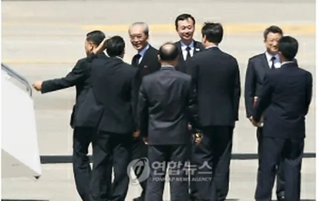 韓国側関係者とあいさつを交わし高麗航空機に乗り込む北朝鮮弔問団＝23日、ソウル（聯合ニュース）