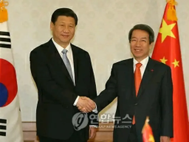 握手を交わす鄭首相（右）と習近平副主席＝17日、ソウル（聯合ニュース）